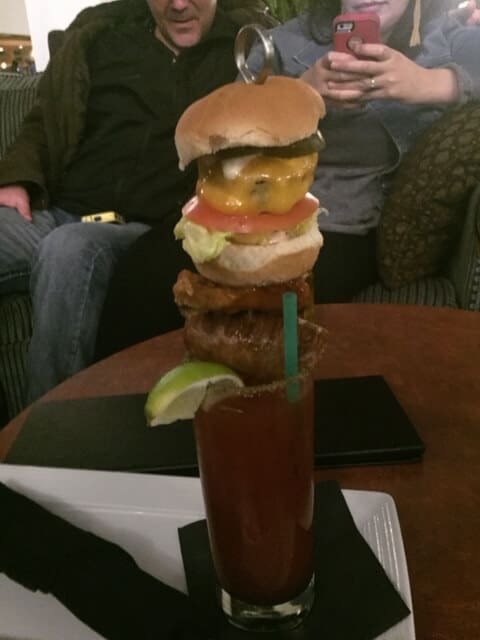 A caesar drink with a burger on top