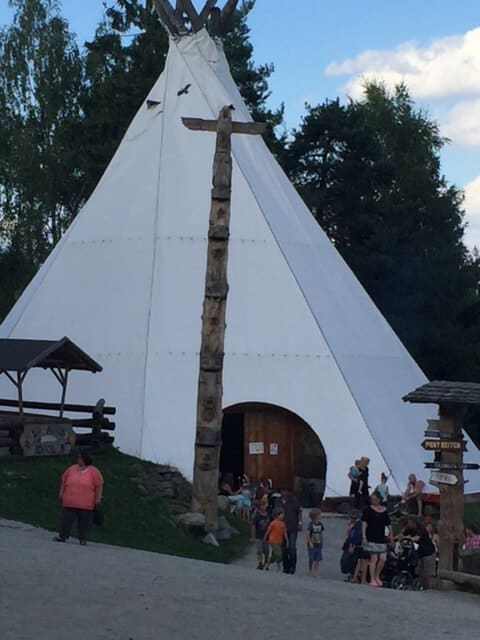 A large teepee shaped building with a crowd of people in front