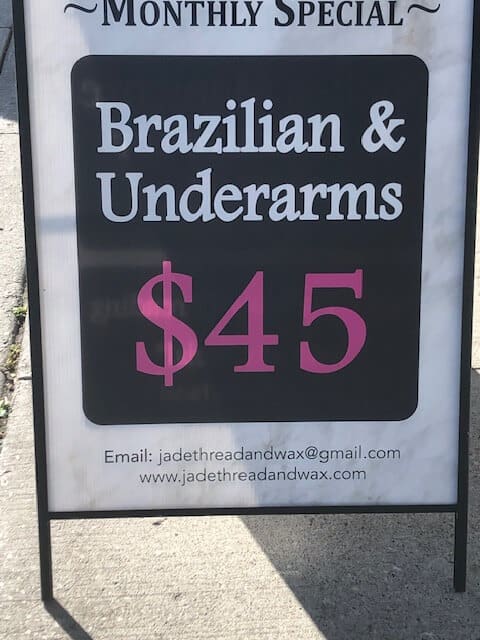 Sidewalk sign that reads "Monthly Special: Brazilian and Underarms, $45"